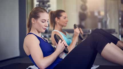 Crunches 2 Frauen crunchen mit Hantelscheibe