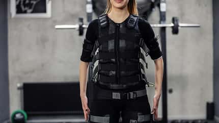 EMS Frau im EMS-Anzug im Fitnessstudio