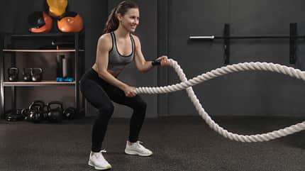 Battle Rope Frau schwingt Battle Rope