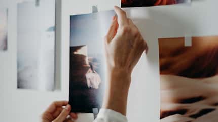 Vision Board, Bilder, Träume, Pinnwand, Ziele Frau hängt Bilder an die Wand