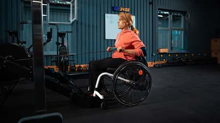 Verletzungen, Gym, Rollstuhl Frau im Rollstuhl trainiert im Fitnessstudio ihren Rücken mit Ruderzügen.