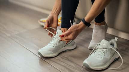Frau bindet sich Sportschuhe zu 