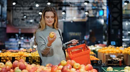 Eine Frau kauft in einem Supermarkt Obst ein Eine Frau kauft in einem Supermarkt Obst ein
