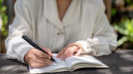 Frau schreibt in Buch Frau schreibt in Buch