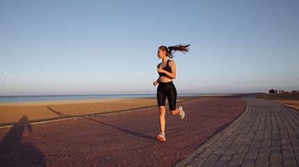 sunrise,sports clothes,activity,sports shoes,jogging,exercise,ca Girl,Runner,In,A,Black,Tracksuit,And,Sneakers,Runs,By