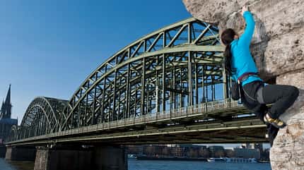 Mann klettert an der Hohenzollernbrücke in Köln Mann klettert an der Hohenzollernbrücke in Köln