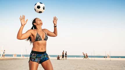 Brasilianerin jongliert einen Ball am Kopf am Strand in Rio De Janeiro Brasilianerin jongliert einen Ball am Kopf am Strand in Rio De Janeiro