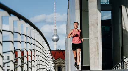 Frau läuft in einem modernen Geschäftsviertel in Berlin, Deutschland Frau läuft in einem modernen Geschäftsviertel in Berlin, Deutschland