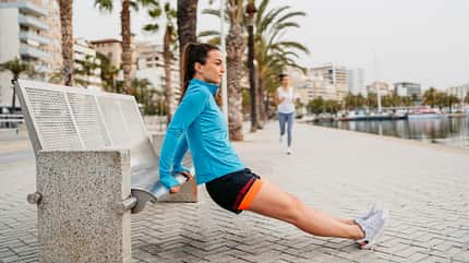 Junge Frau Macht Trizeps-Dips Auf Der Bank Am Kai In Palma De Mallorca In Spanien Junge Frau Macht Trizeps-Dips Auf Der Bank Am Kai In Palma De Mallorca In Spanien