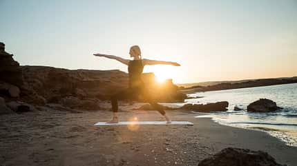 Frau macht Yoga am Strand in Griechenland Frau macht Yoga am Strand in Griechenland