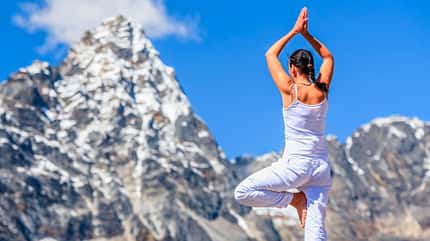 Frau macht Yoga-Pose in den Bergen Frau macht Yoga-Pose in den Bergen