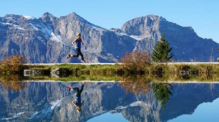 Eine Frau joggt an einer Berglandschaft Eine Frau joggt an einer Berglandschaft