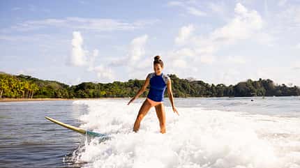 A woman catches a wave while surfing in Costa Rica. A woman catches a wave while surfing in Costa Rica.