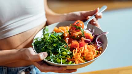 Trainierte Frau mit Salatbowl