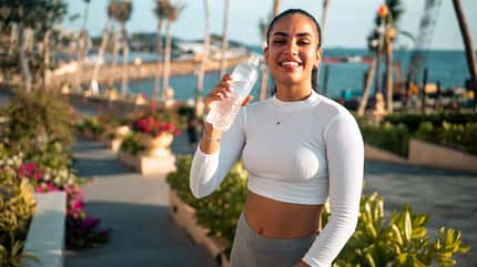 Fitte junge Frau trinkt Wasser nach dem Training Fitte junge Frau trinkt Wasser nach dem Training