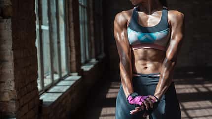 activity Close up view of fit strong beautiful sporty muscular athlete woman trainer bodybuilder core wear sportswear standing in sunny gym indoors, bodybuilding workout exercises background concept