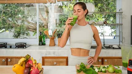 Frau trinkt Glas mit einem Green Smoothie