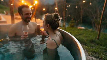 Glückliches Paar mit Sekt im Pool Glückliches Paar mit Sekt im Pool