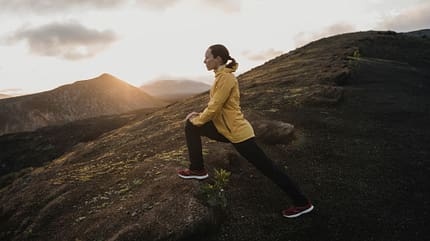 Frau macht Fitnessübungen bei Sonnenaufgang