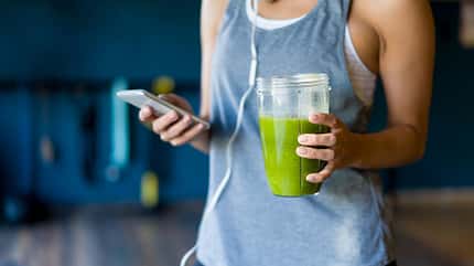 Frau hält Green Smoothie in der Hand Frau hält Green Smoothie in der Hand