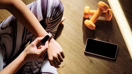 Frau schaut auf Fitnessuhr Frau schaut auf Fitnessuhr