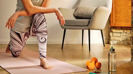 Eine Frau macht Übungen auf einer Yogamatte Eine Frau macht Übungen auf einer Yogamatte