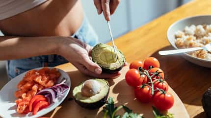 Eine Frau schneidet eine Avocado