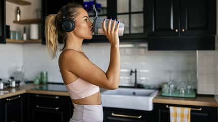 Frau in Sportkleidung trinkt Proteinshake Frau in Sportkleidung trinkt Proteinshake