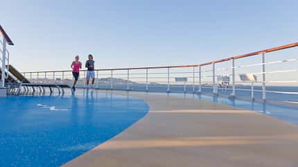 Ein junges Paar joggt auf einem Schiffdeck