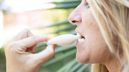 Eine Frau beißt in ein Mochi-Eis
