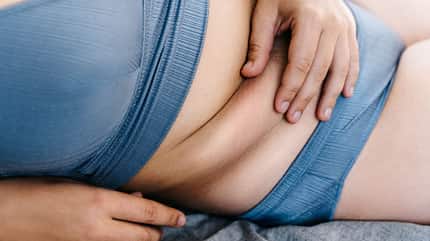 Eine kurvige Frau greift sich an ihren Bauch Eine kurvige Frau greift sich an ihren Bauch