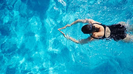 Eine Frau schwimmt im Pool Eine Frau schwimmt im Pool
