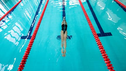 Eine Frau beim Rückenschwimmen im Pool Eine Frau beim Rückenschwimmen im Pool