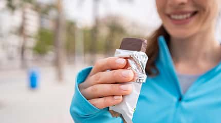 A post-workout treat young girl eats a protein bar A post-workout treat young girl eats a protein bar