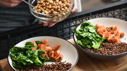 Eine Frau bereitet Salatbowls zu Eine Frau bereitet Salatbowls zu