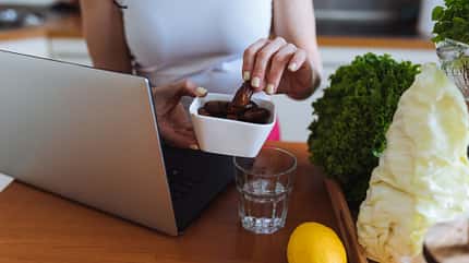 Eine Frau snackt beim Arbeiten Datteln Eine Frau snackt beim Arbeiten Datteln