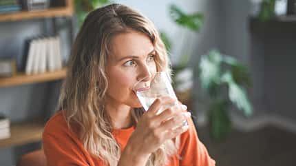 Eine Frau trinkt aus einem Glas Eine Frau trinkt aus einem Glas