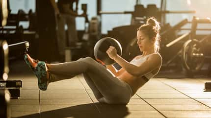 Eine Frau macht Russian Twists mit Gewicht