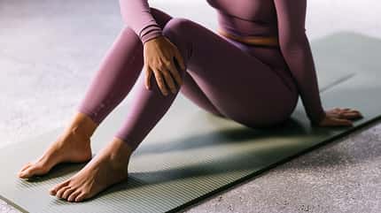 Woman in Yoga Pose Relaxing on Exercise Mat Woman in Yoga Pose Relaxing on Exercise Mat