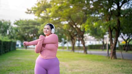 Eine Frau stretcht sich draußen Eine Frau stretcht sich draußen