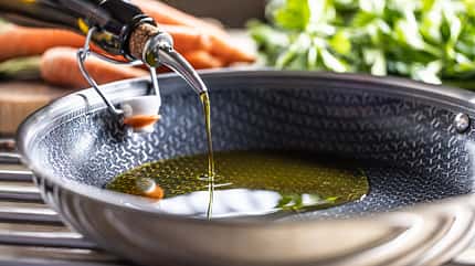 Olivenöl wird in eine Pfanne gegossen Olivenöl wird in eine Pfanne gegossen