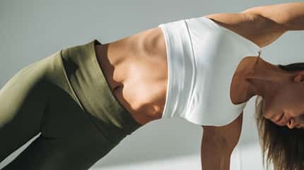 Eine Frau trainiert ihren flachen Bauch mit Pilates-Übungen Eine Frau trainiert ihren flachen Bauch mit Pilates-Übungen