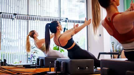 Frauen von hinten beim Pilates-Workout Frauen von hinten beim Pilates-Workout