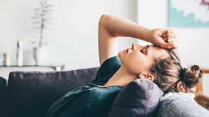 Sad and depressed woman sitting on sofa at home. Sad and depressed woman sitting on sofa at home.