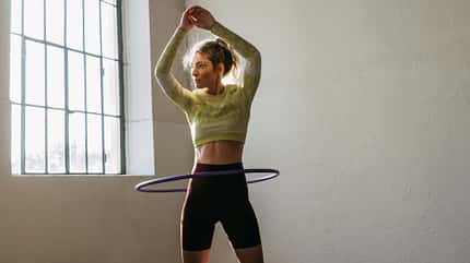 Eine trainierte Frau wirbelt Hula Hoop