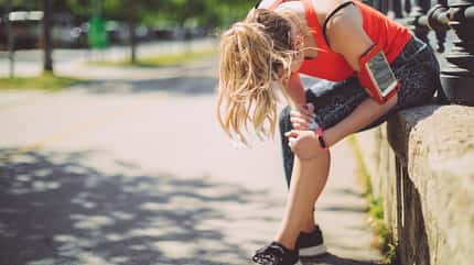 Eine sportliche Frau hält sich ihr Knie Eine sportliche Frau hält sich ihr Knie