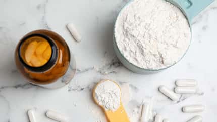 Kreatinpulver und Kapseln auf Marmor-Untergrund Kreatinpulver und Kapseln auf Marmor-Untergrund