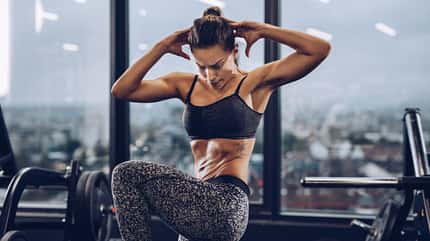 Eine Frau trainiert ihren Bauch im Stehen Eine Frau trainiert ihren Bauch im Stehen