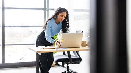 Eine Frau arbeitet im Stehen am Laptop Eine Frau arbeitet im Stehen am Laptop