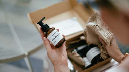 Eine Frau schaut sich in einem Paket verschiedene Cremes an